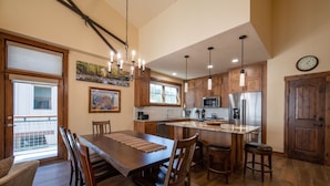 A kitchen with wooden cabinets, a central island, and a dining area with a large table and chairs.