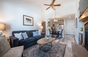 A living room with a sofa, coffee table, and a ceiling fan.