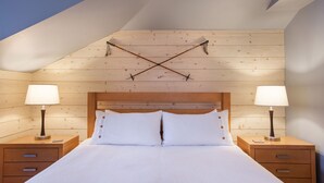 A bedroom with a wooden headboard, two bedside tables with lamps, and a bed with white bedding. - Fraser Crossing/Founders Pointe, Condo | 2 Bedroom (Value-Rated Condo 3426) (Winter Park)
