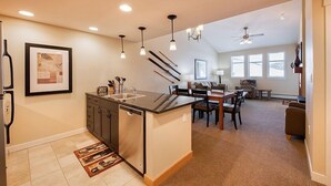 A modern kitchen with a central island, recessed lighting, and a dining area with a table and chairs. - Fraser Crossing/Founders Pointe, Condo | 2 Bedroom (Value-Rated Condo 3426) (Winter Park)