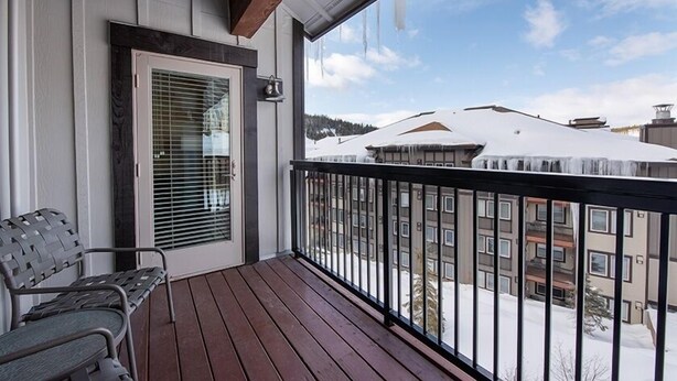 A wooden deck with a metal railing, a bench, and a door with blinds. - Fraser Crossing/Founders Pointe, Condo | 2 Bedroom (Value-Rated Condo 3426) (Winter Park)
