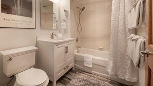 Ein modernes Badezimmer mit Toilette, Waschtisch, Spüle und Dusche.