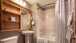Une salle de bain avec des toilettes, un lavabo et une baignoire.