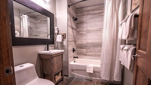Une salle de bain avec des toilettes, un lavabo et une baignoire.