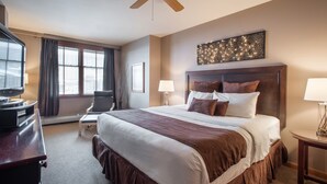 A hotel room with a large bed, a desk, a chair, a ceiling fan, and a window with curtains. - Zephyr Mountain Lodge, Condo | 2 Bedroom (Select-Rated Condo 1415) (Winter Park)