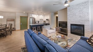 A modern living room with a blue sofa, a coffee table, and a fireplace. - Zephyr Mountain Lodge, Condo , 3 Bedroom (Premium-Rated Condo 2505) (Winter Park)