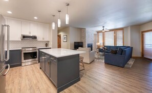 A modern kitchen with stainless steel appliances, a central island, and pendant lighting. - Zephyr Mountain Lodge, Condo , 3 Bedroom (Premium-Rated Condo 2505) (Winter Park)