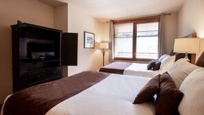 A hotel room with two beds, a TV, a desk, and a window with curtains. - Zephyr Mountain Lodge, Condo | Ski Slope View (Select-Rated Condo 2405) (Winter Park)