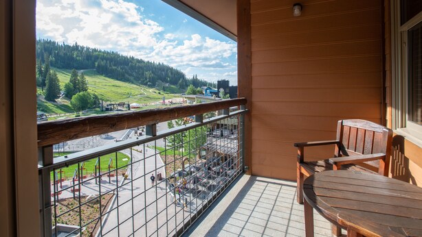 A balcony with a view of a green landscape and a parking area. - Zephyr Mountain Lodge, Condo | Ski Slope View (Select-Rated Condo 2405) (Winter Park)