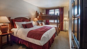 A hotel room with a large bed, two bedside tables, a window with curtains, and a wooden headboard. - Zephyr Mountain Lodge, Condo | Ski-In/Ski-Out w/ Balcony Views (Value-Rated Condo 1516) (Winter Park)