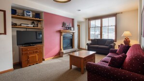 A living room with a television, fireplace, sofa, and coffee table. - Zephyr Mountain Lodge, Condo | Ski-In/Ski-Out w/ Balcony Views (Value-Rated Condo 1516) (Winter Park)
