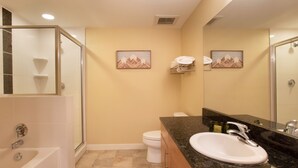 A modern bathroom with a glass-enclosed shower, a white bathtub, a sink with a granite countertop, and two framed pictures on the wall. - Fraser Crossing/Founders Pointe, Condo | Gondola Access (Premium-Rated Condo 3624) (Winter Park)
