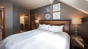 A bedroom with a large bed, wooden headboard, and four wall-mounted circular wall art pieces. - Zephyr Mountain Lodge, Condo | Ski Storage (Select-Rated Condo 2700) (Winter Park)