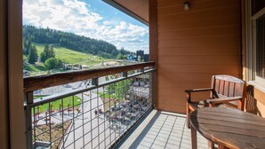 Un balcón con vista a un paisaje verde y un estacionamiento.