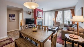 Un soggiorno moderno con un tavolo da pranzo in legno, un divano e una televisione.