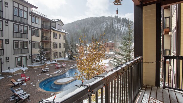 Area piscina con lettini e un paesaggio innevato sullo sfondo.