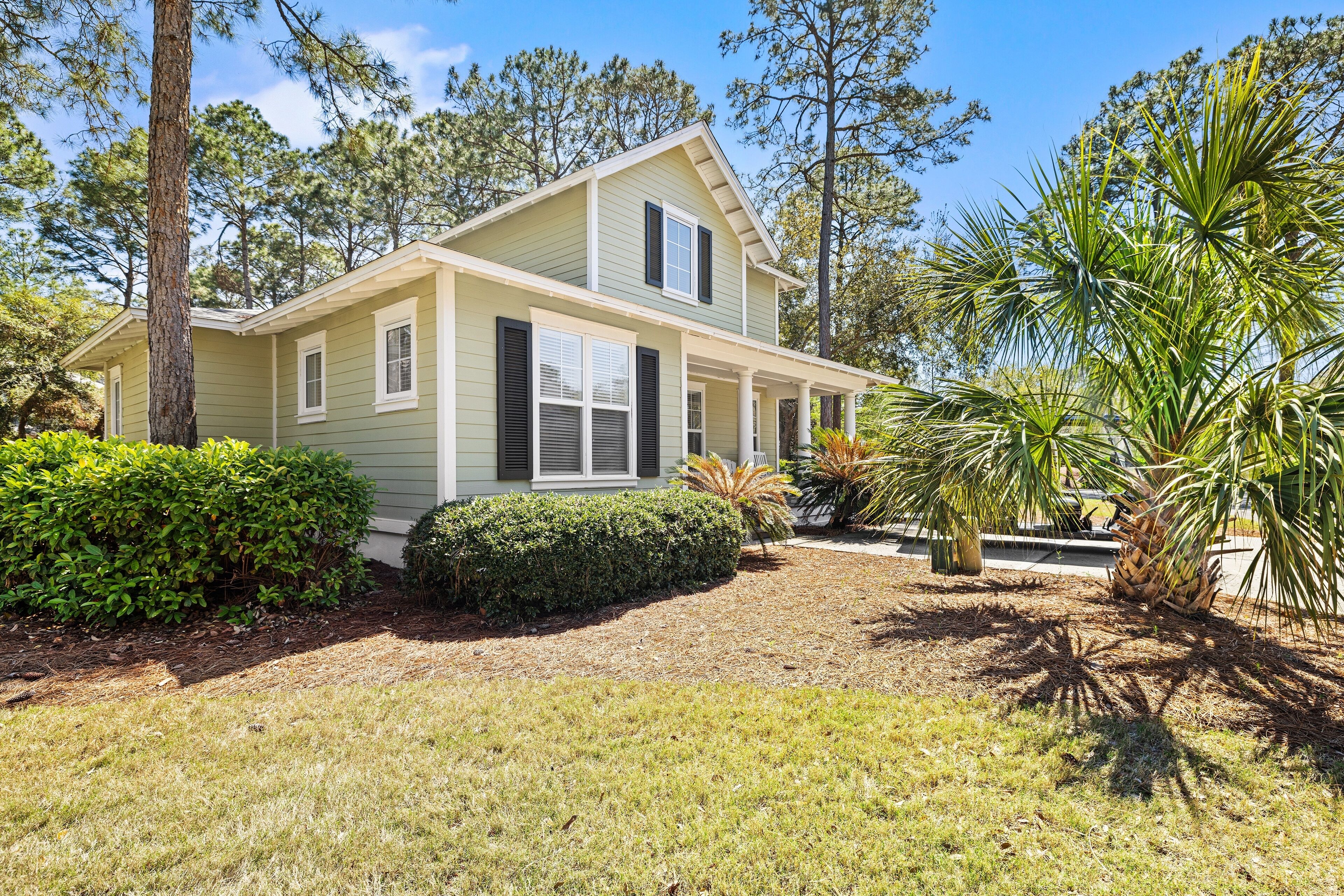 A two-story house with a covered porch and a well-maintained lawn.