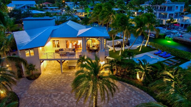 A resort with a pool, palm trees, and a view of the surrounding area. - 5BR/4.5BA • Ocean Views • Pool & Hot Tub • Dock • Kayaks • Bikes & More (Key Largo)