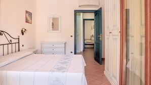 A bedroom with a bed, a dresser, a mirror, and a wardrobe.