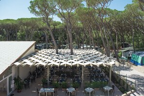Enjoy al fresco dining under a shaded pergola surrounded by lush greenery.
