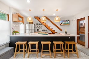 Enjoy cooking in the kitchen with a central island, bar stools, microwave, and large window.