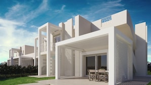 Un edificio residencial moderno con techo plano, ventanas amplias y un área de estar exterior cubierta.