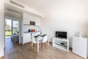 Eine moderne Küche mit weißen Schränken, einer Mikrowelle und einem Essbereich mit Tisch und Stühlen.