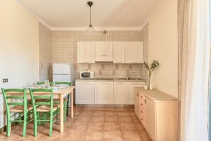 Una cuina compacta amb zona de menjador, que disposa d'un microones, un rentaplat i armaris.