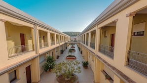 A corridor with balconies and potted plants. - Two-room apartment with 4 beds, about 45 m2, living room with kitchenette and double sofa bed, bedroom with double bed (separable beds), bathroom with toilet, bidet and shower. Possibility 1 infant in cot. <br>The charming apartments can be arranged on t (Villasimius)
