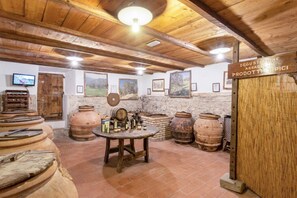 A rustic cellar with wooden beams, terracotta barrels, and a sign indicating the production of typical products. - Villa Grassina Trilocale sleeps 6, 2 bathrooms, WIFI, pool (Pelago)