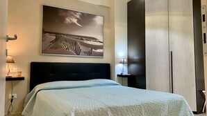 A bedroom with a bed, a wall-mounted artwork, bedside lamps, and a wardrobe. - Apartment 3 rooms furnished with taste, 55/60mq, kitchenette / living room and double sofa bed or two sofa beds, matrimonial bedroom, double bedroom, bathroom.Included of:<br>tv, <br><b>washing machine<b>, <br><b>balcony or small garden <b>, <br>parking  (Massa)