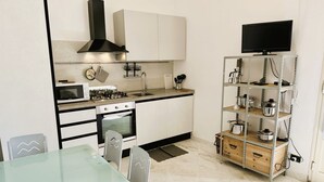 A compact kitchen with a microwave, stove, oven, and a TV mounted on a shelf. - Apartment 3 rooms furnished with taste, 55/60mq, kitchenette / living room and double sofa bed or two sofa beds, matrimonial bedroom, double bedroom, bathroom.Included of:<br>tv, <br><b>washing machine<b>, <br><b>balcony or small garden <b>, <br>parking  (Massa)