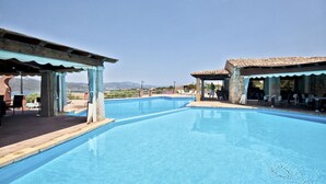 A swimming pool with a clear view of the surrounding landscape, including distant hills and a clear sky.