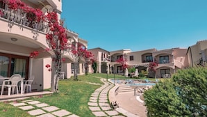 A hotel courtyard with a swimming pool, outdoor seating, and a well-maintained lawn. - Badus Two-room apartment, WIFI, A.C, swimming pool (Badesi)