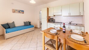 A compact living space with a sofa, dining table, and kitchenette.
