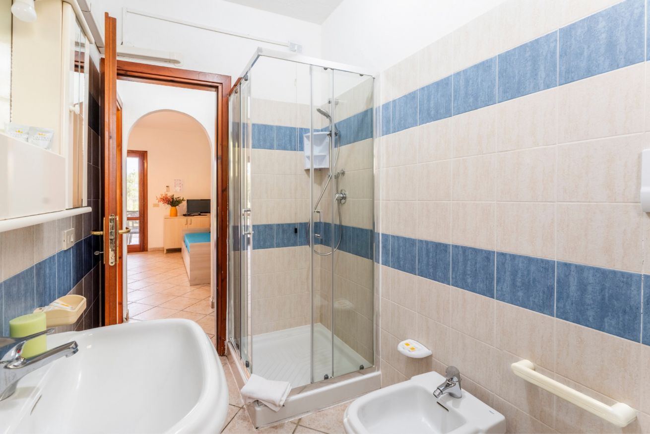 Ein Badezimmer mit zwei Waschbecken, einer Duschkabine aus Glas und einer Toilette.