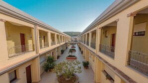 A corridor with balconies and potted plants.