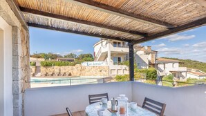 A balcony with a table set for two, overlooking a pool and a building labeled "Eabiança". - Three-room apartment with 6 beds, sea view, about 65/70 sq m, living room with kitchenette, double or twin sofa bed, double bedroom, one twin bedded room or with bunk bed, bathroom. Side or front sea view. <br>Apartments arranged on different levels. Spa (Baja Sardinia)