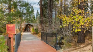 A pathway leading to a cabin in a forested area with a sign indicating recreation center rules. - Rendezvous at Northstar_3 Story High End Condo, Nest, Alexa, Remote Fireplace, Smart TV's +NPOA Pass (Truckee)