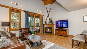 A spacious living room with a fireplace, wooden flooring, leather furniture, and a television displaying a streaming service. - Rendezvous at Northstar_3 Story High End Condo, Nest, Alexa, Remote Fireplace, Smart TV's +NPOA Pass (Truckee)