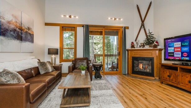A living room with a leather sofa, a coffee table, a fireplace, and a television displaying streaming services. - Rendezvous at Northstar_3 Story High End Condo, Nest, Alexa, Remote Fireplace, Smart TV's +NPOA Pass (Truckee)