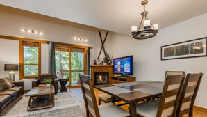 A cozy living room with a fireplace, wooden furniture, and large windows. - Rendezvous at Northstar_3 Story High End Condo, Nest, Alexa, Remote Fireplace, Smart TV's +NPOA Pass (Truckee)