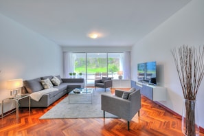 Departamento familiar, 2 habitaciones, refrigerador y microondas (Residenza Parco Carona) | Sala de estar | Smart TV de 21 pulgadas con canales vía satélite