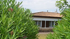 Ein Haus mit Ziegeldach, umgeben von üppigem Grün.