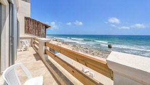 A balcony with a view of the ocean, wooden railing, and white chairs. - Steps to Sand- Serene Beachfront Getaway in Isla Mujeres, Mexico. (Isla Mujeres)