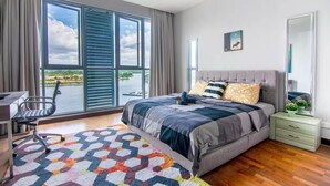 Un dormitorio con una cama grande, un escritorio y vistas al exterior.