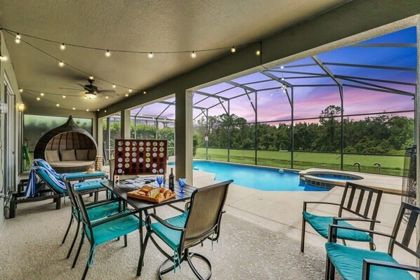 Relax by the pool, surrounded by lush greenery and comfortable seating.