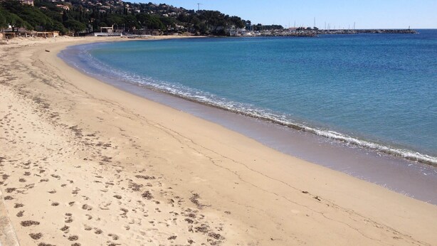 A sandy beach with footprints, a clear blue sea, and a distant shoreline with buildings. - Apt With Pool   Magnificent Sea View, 80m To Beach (Sainte-Maxime)