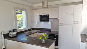 A modern kitchen with a central island, stainless steel appliances, and a window providing natural light. - Apt With Pool   Magnificent Sea View, 80m To Beach (Sainte-Maxime)