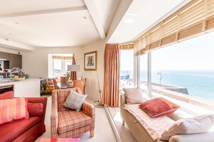 Una sala de estar moderna con sofá, sillón y comedor.